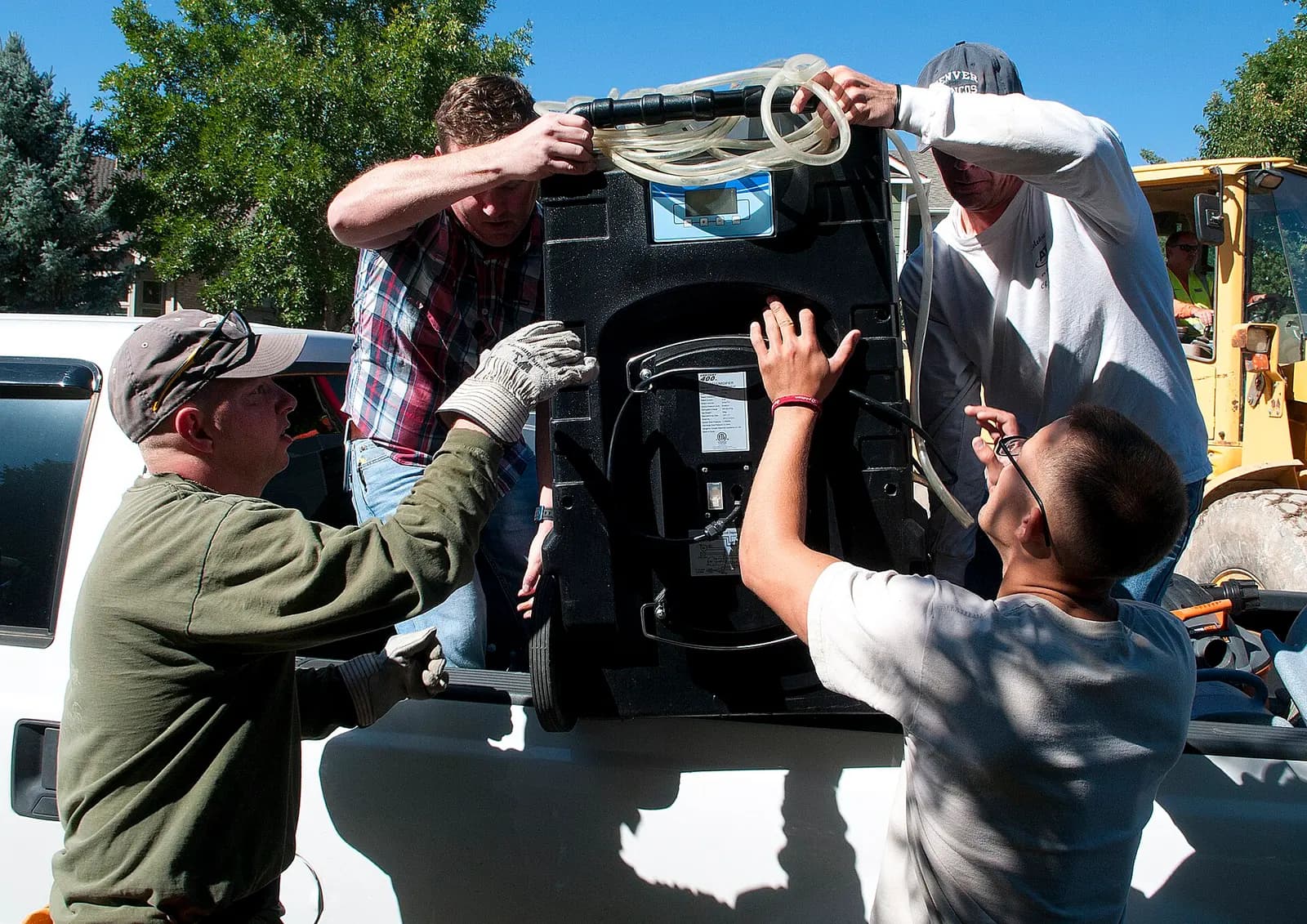 A crew loading a commercial dehumidifier after a flood. Shown on the Roof dry-out page for Syracuse, NY.